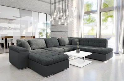 A modern living room with a large sectional sofa, coffee table, and large windows.