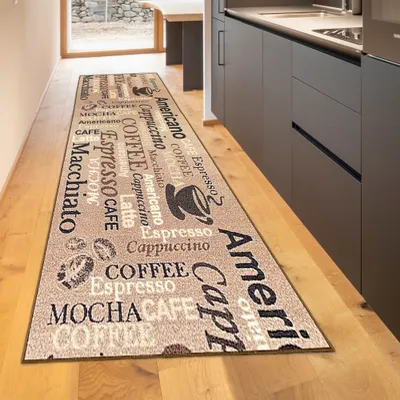 A long runner rug with coffee-related text and graphics is laid out on a wooden floor in a kitchen or hallway.