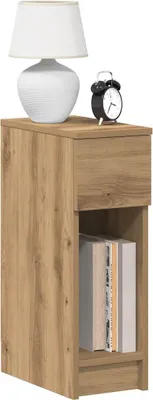 A bedside table with a lamp and an alarm clock on top, and books on the shelf.