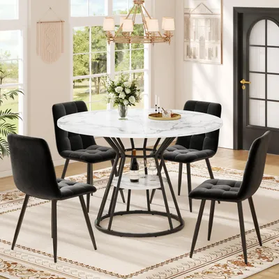 A dining room scene with a round marble-look table and four black velvet chairs, set against a backdrop of windows and a door.