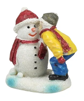 Man sieht fröhlichen Schneemann. Neben ihm beugt sich Kind das dem Schneemann etwas ins Ohr flüstert