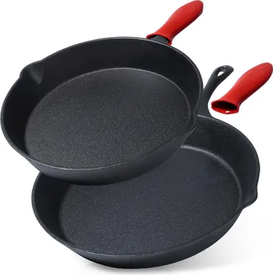 Two cast iron frying pans with red silicone handle covers, stacked on a white background.