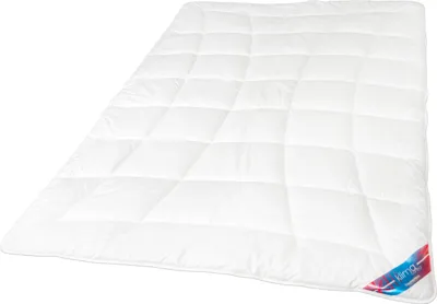 A white quilted comforter is shown laid out on a white background.