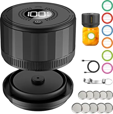 A black electric vacuum sealer for jars is shown with various accessories, including colorful labels, a USB cable, and a jar of preserved food.