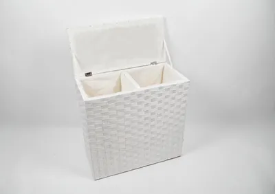 A white, woven laundry hamper with two compartments and an open lid, set against a white background.