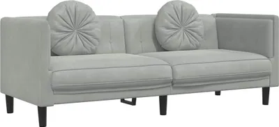 A light gray, three-seater sofa with two round decorative pillows is shown against a white background.