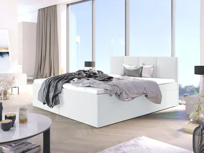 A modern bedroom with a large white bed and floor-to-ceiling windows.
