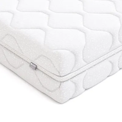 A close-up view of a white mattress corner with a quilted pattern and a zipper.
