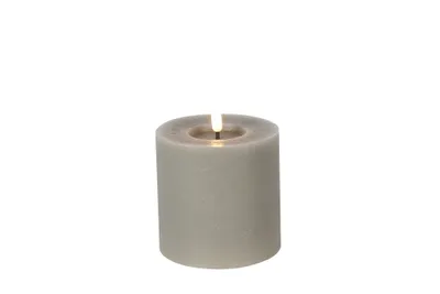 A single, lit LED candle on a white background.