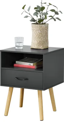 A dark gray nightstand with wooden legs, a drawer, and an open shelf, decorated with a plant in a woven pot and a glass of water.