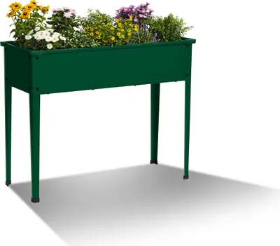 A green metal raised garden bed filled with various flowers and plants, set against a white background with a shadow.