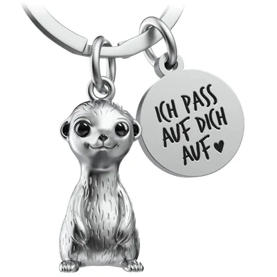 A silver meerkat keychain with a round charm engraved with text.