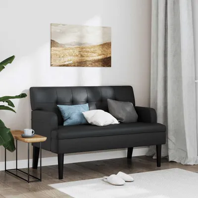 A black faux leather bench with cushions is placed in a room with a painting on the wall and curtains in the background.