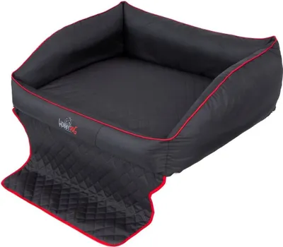 A black dog bed with red trim and a quilted mat extending from the front.