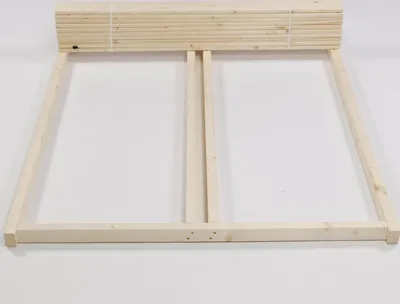 A wooden bed frame laid out on a white background.