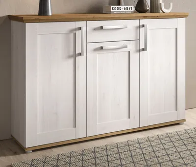 A white sideboard with wood accents is shown in a room with a rug.