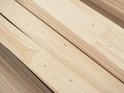 Close-up view of stacked light-colored wooden planks.