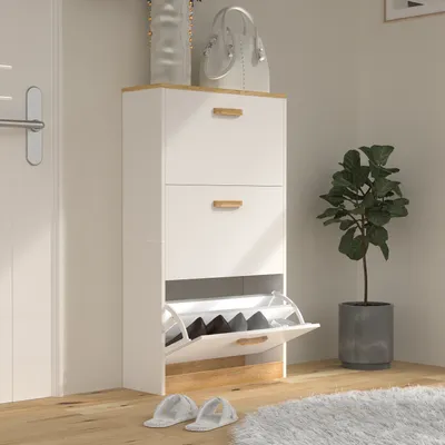 A white shoe cabinet with wooden accents is shown in a room with a white door and a potted plant.