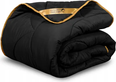 A folded black comforter with gold trim and a gold ribbon with a logo and text.