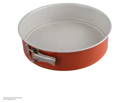 A round springform cake pan with a red exterior and a white interior, shown from a slightly elevated side angle against a white background.