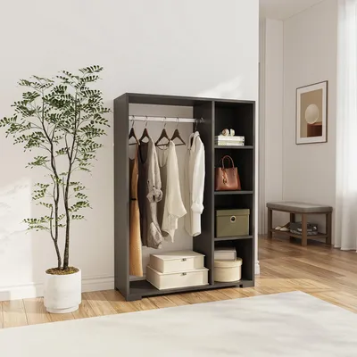 A wardrobe with clothes hanging on a rail and shelves with storage boxes and a handbag.