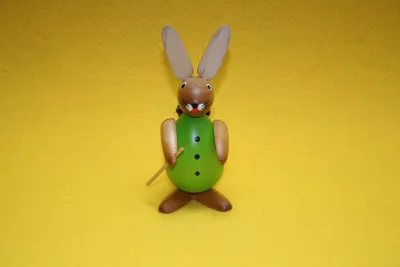 Productafbeelding van Paashaas. Bruine haas met een groen lichaam, een rugzakmand en een wandelstok. Hoogte: 11 cm. Nieuw