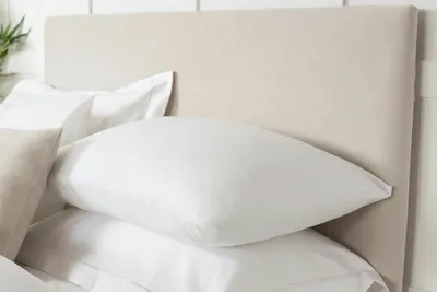 A close-up view of a bed with pillows and a headboard.