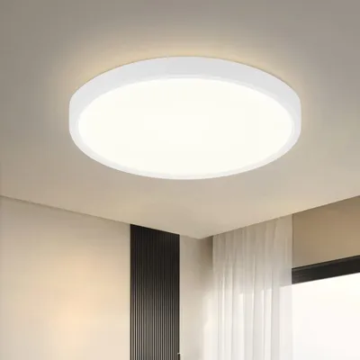 A white, circular LED ceiling light mounted on a light-colored ceiling.