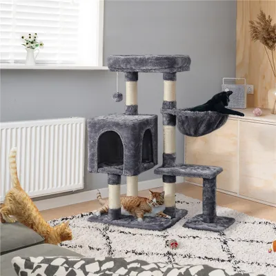 A cat tree with two cats in a living room setting.