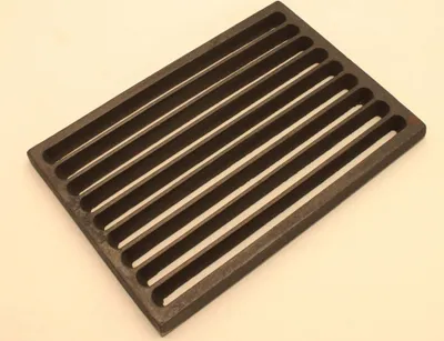 A dark gray cast iron grate with parallel raised bars on a light gray background.