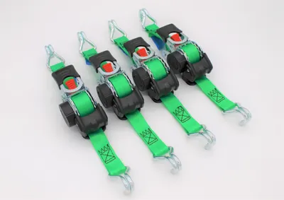 Four green ratchet straps with metal hooks are laid out diagonally on a white background.