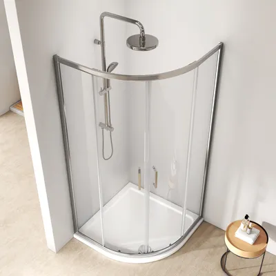 A modern shower cabin with a curved glass door and a chrome shower fixture.