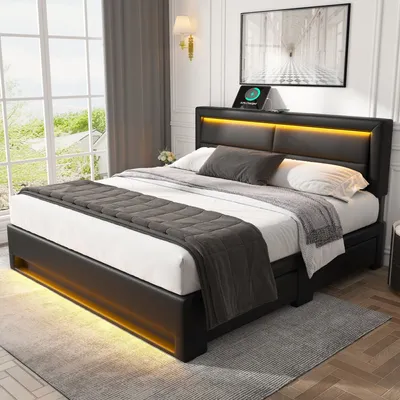 A modern bedroom with a black upholstered bed with LED lighting.