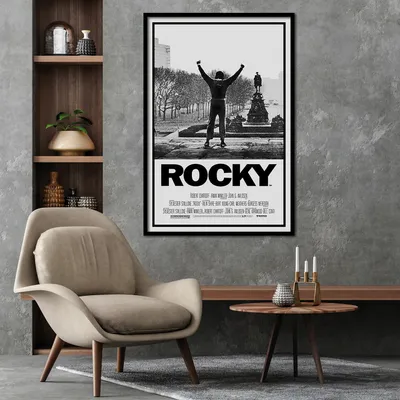 A movie poster for Rocky is displayed on a wall above a chair and a coffee table.