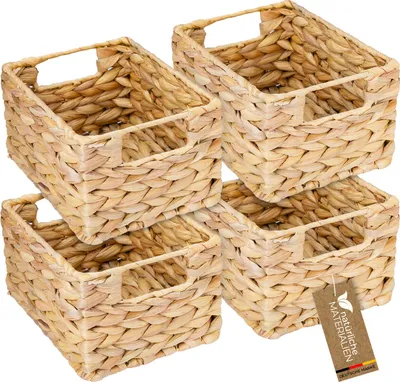 A set of four woven storage baskets made from water hyacinth, stacked and arranged for a product shot.