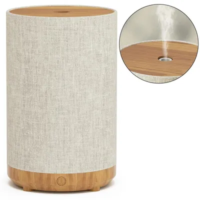 A humidifier diffuser with a fabric exterior and wood-grain base and top.