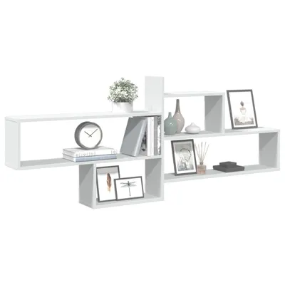 A white modular shelving unit is displayed against a white background, showcasing various decorative items and books.