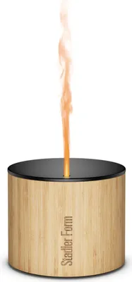 A Stadler Form aroma diffuser with a bamboo casing and aluminum lid, emitting a flame-like vapor.
