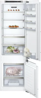 An open refrigerator with shelves and drawers containing food items.