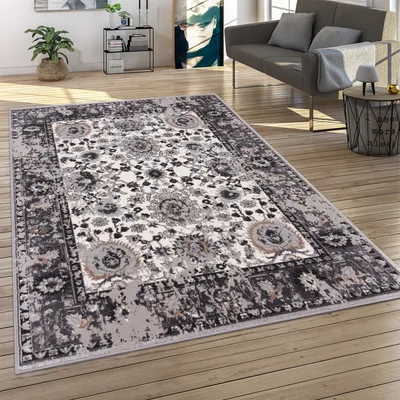 A living room scene with a rug on the floor, a sofa, and a side table.
