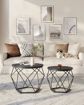 A living room scene with a sofa, coffee tables, and wall art.