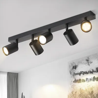 A black ceiling light fixture with five adjustable spotlights is mounted on a white ceiling.
