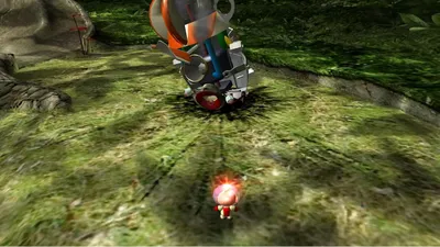 A small, pink, cartoonish character with red accents is running towards a large, metallic, broken-down machine in a grassy, outdoor environment.