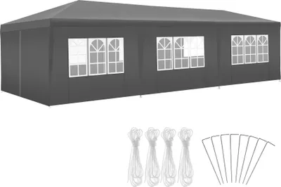 A dark gray pavilion with windows and accessories laid out below it.