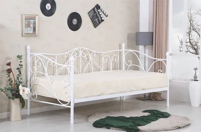 A white metal daybed with a mattress is shown in a room setting.