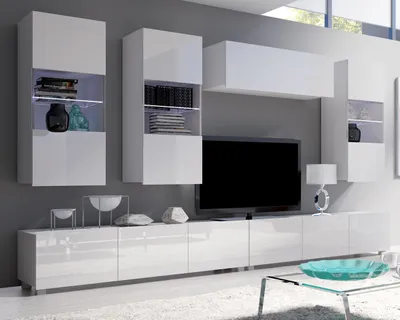 A modern white high-gloss media wall unit with integrated cabinets and shelves, displaying decorative items and a television.