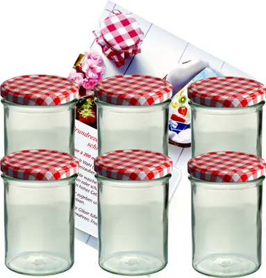 A set of six glass jars with red and white checkered lids, arranged in two rows of three, with a blurred background featuring a recipe booklet and flowers.