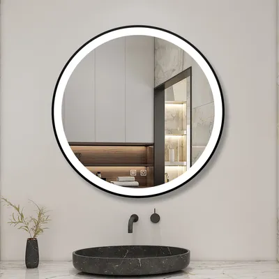 A round LED mirror is mounted on a wall above a marble sink in a modern bathroom.