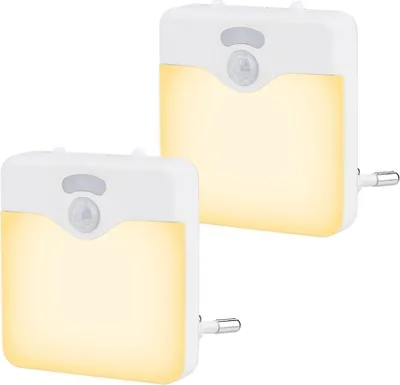 Two white LED night lights with a warm yellow glow are shown against a white background.
