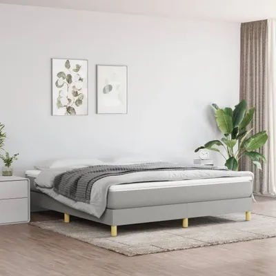 A bedroom scene with a bed, nightstand, and artwork.